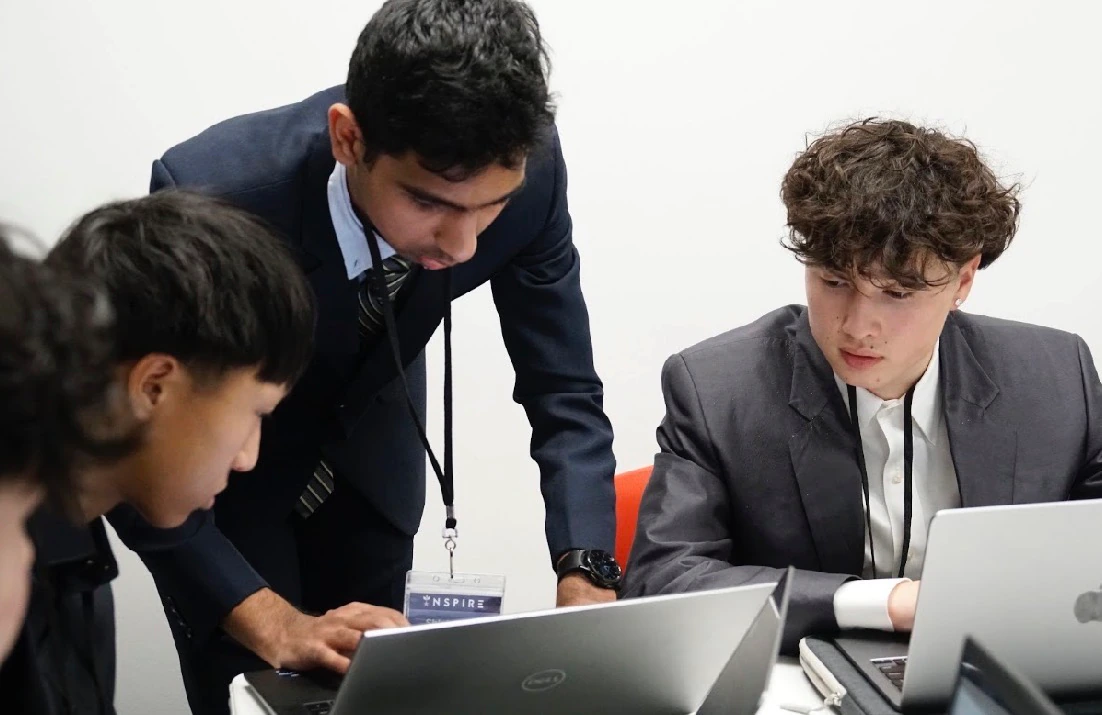 INSPIRE participants discussing their case around laptops